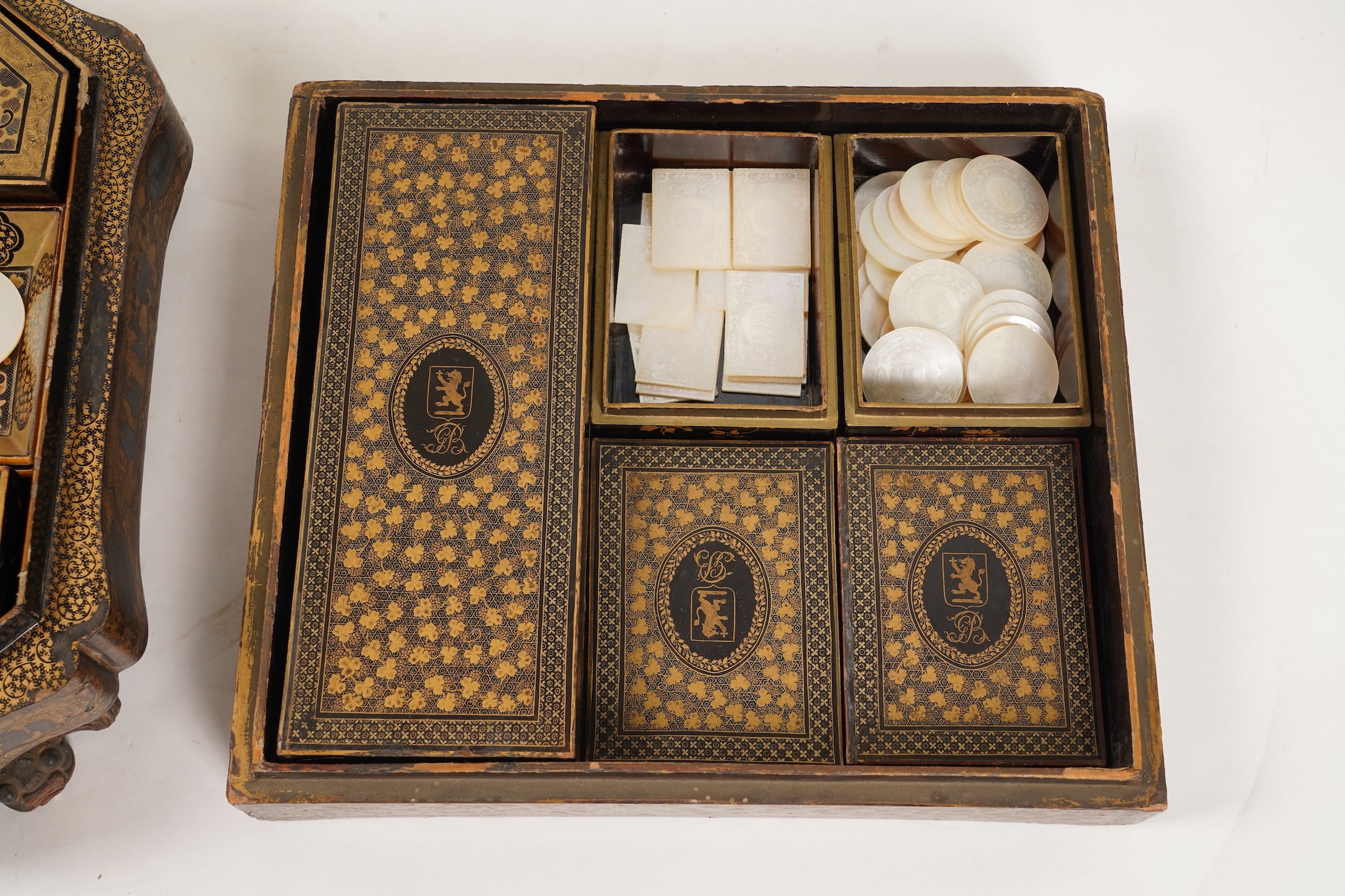 Two Chinese gilt decorated black lacquer games boxes, containing numerous mother-of-pearl counters, 19th century